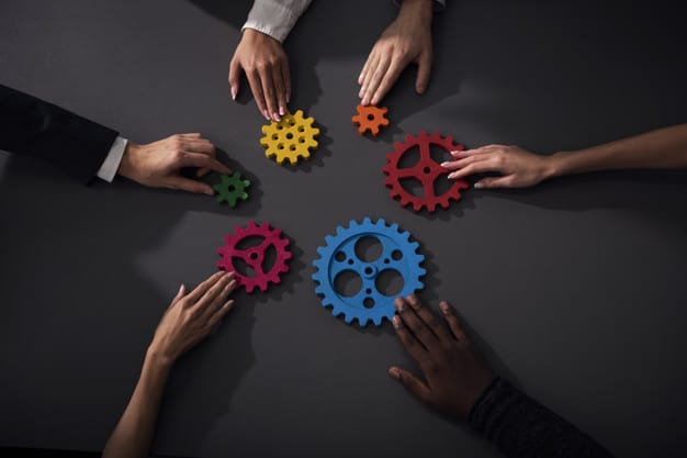 Teamwork of businesspeople work together and combine pieces of gears. Partnership and integration concept